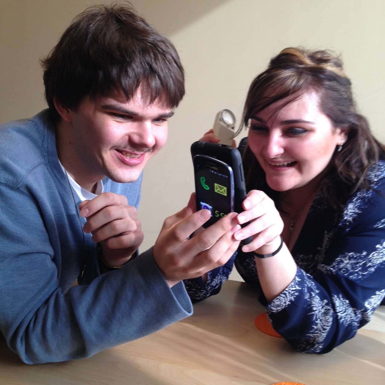 Two young people share photos on a smartphone